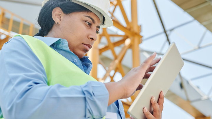 A construction manager using a tablet at a job site