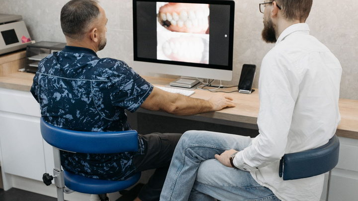 Dental professionals reviewing digital patient imaging on a computer