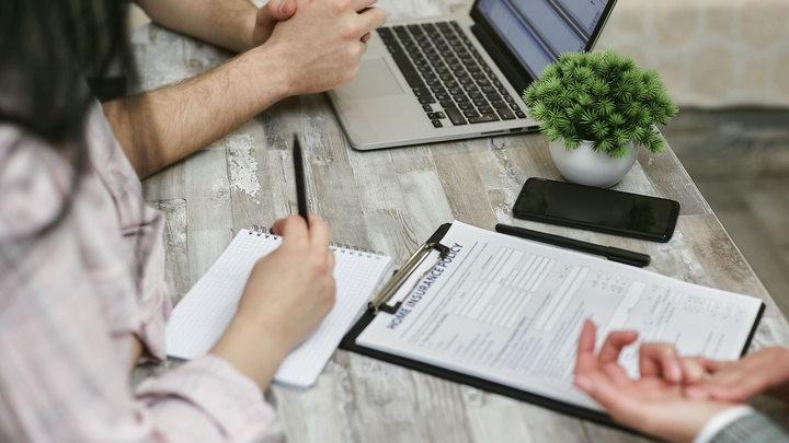Insurance professionals reviewing policy documents and a laptop