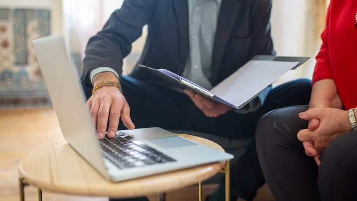 An attorney reviewing documents and a laptop with a client