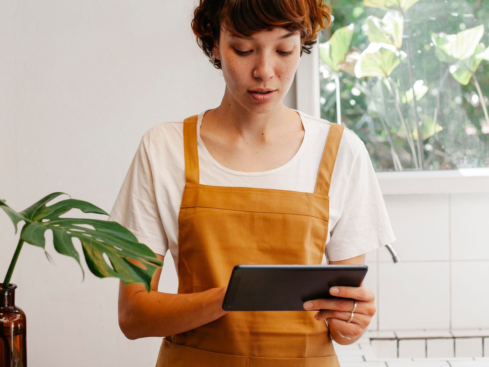 A restaurant employee using a tablet at the service counter